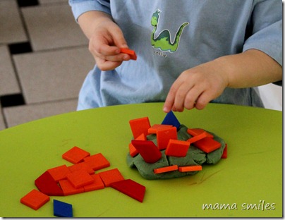 Johnny balances pattern blocks in play dough
