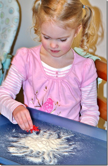 Emma makes dinosaur tracks in cornmeal