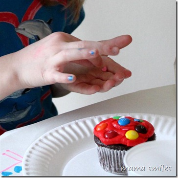 carefully decorating a cupcake