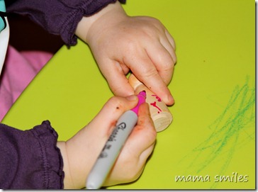 Lily decorates her peg doll