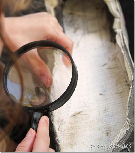 examining a shoe with a magnifying glass