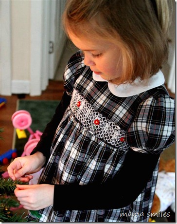 Emma hangs a Christmas tree ornament